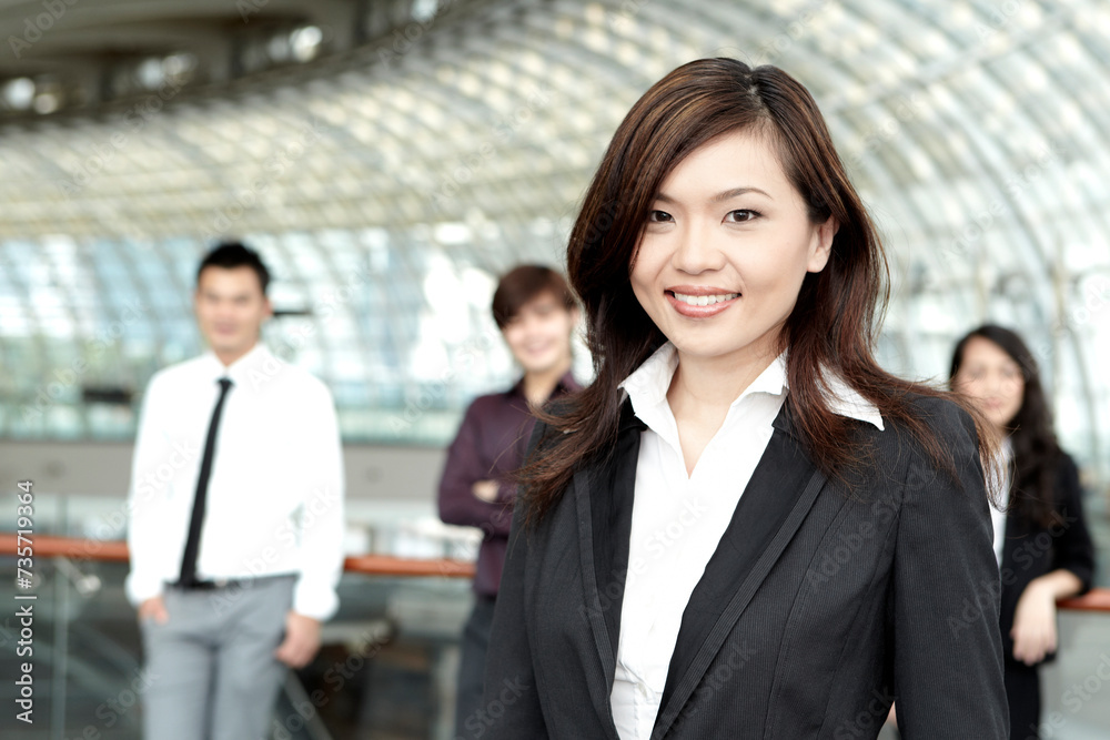 Business woman with colleagues in the background Business woman with colleagues in the background