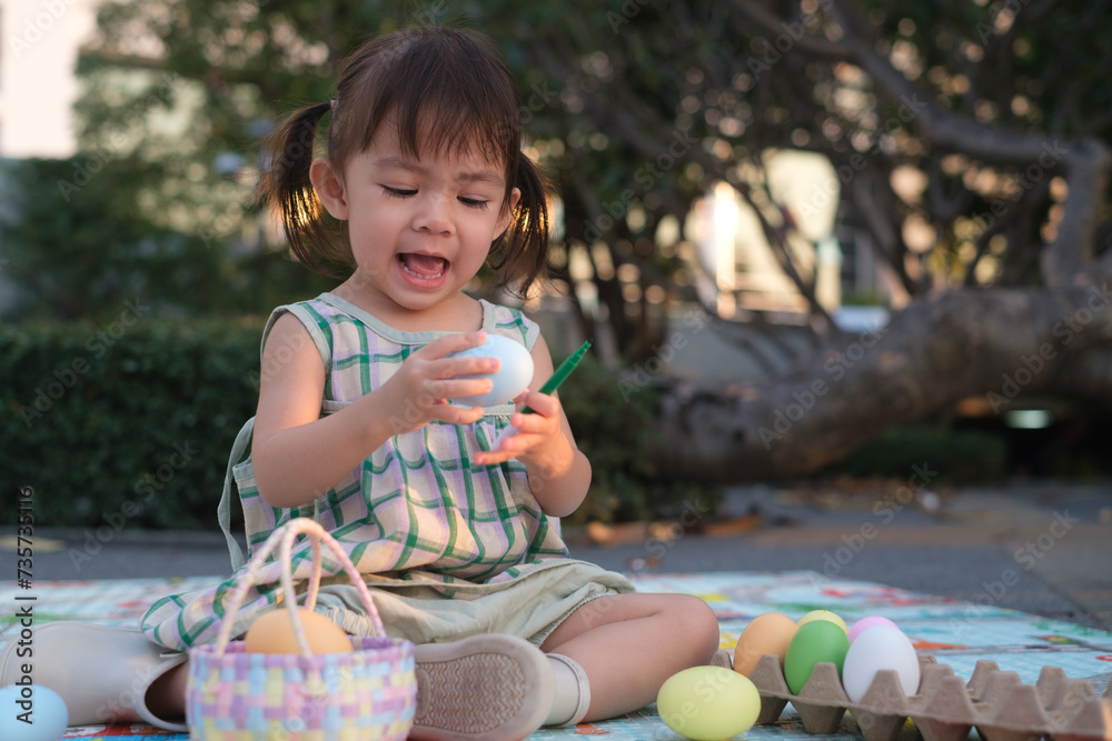 Little kid girl paint Easter eggs inthe garden. children are preparing for Easter. Happy and fun in easter festival holiday. Little kid girl paint Easter eggs inthe garden. children are preparing for Easter. Happy and fun in easter festival holiday.
