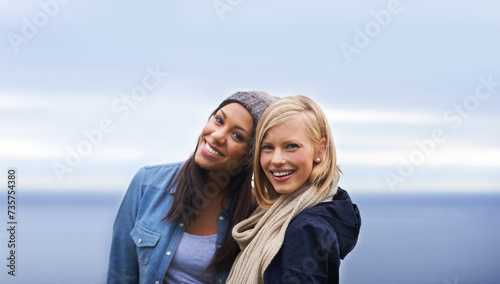 Friends, happy and portrait of women by ocean for adventure on holiday, vacation and weekend outdoors. Nature, travel and people by seaside for relaxing, happiness and bonding together in countryside