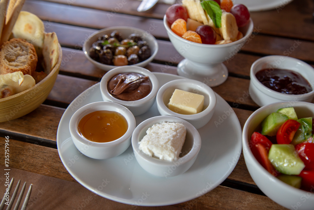 breakfast platter, chocolate, honey, butter, cream butter on a wooden table. breakfast platter, chocolate, honey, butter, cream butter on a wooden table.