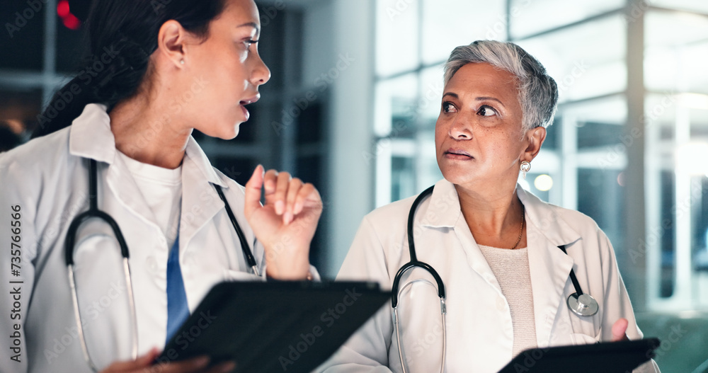 Fototapeta premium Doctors night planning and tablet with talking, medical data and research in a hospital with women. Working, online and diagnosis discussion for healthcare, wellness and clinic job with conversation