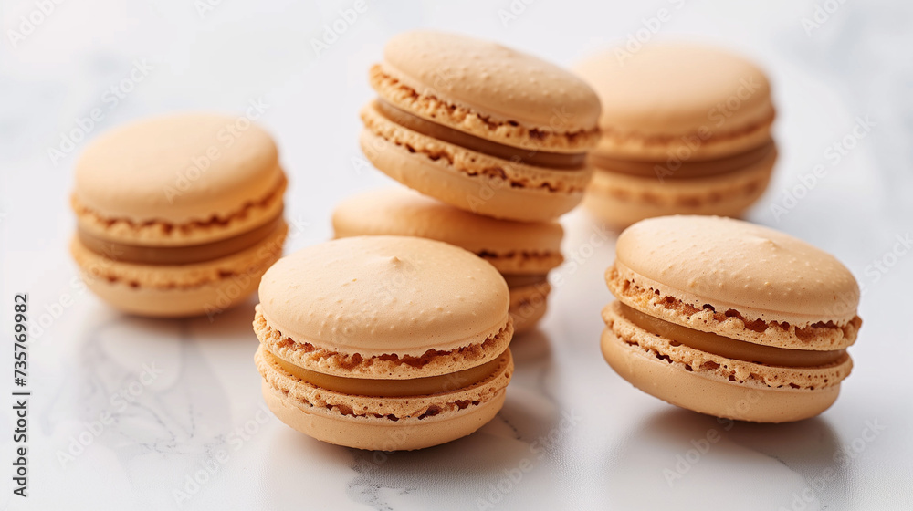 Beige monochrome background with balanced macaroons. Macarons french pastries. Isolated white macarons collection. Vanilla or coconut macaroon at different angles isolated on white background. 