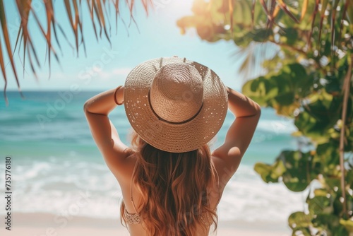 Eine junge Frau mit einem Sonnenhut am Strand im Urlaub  photo
