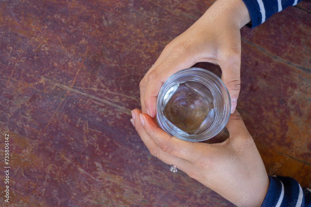 Top view a hand catching glass of water on the table