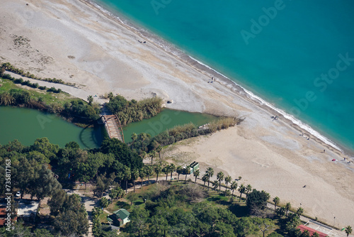 Fototapeta Naklejka Na Ścianę i Meble -  Aerial drone view of the Sarisu beach in Antalya (Turkey) - coastline with palm trees, sand and bridge - tropical vacation resort