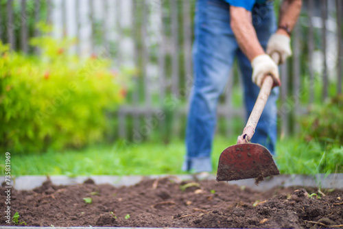 Valokuva Farmer cultivating land in the garden with hand tools