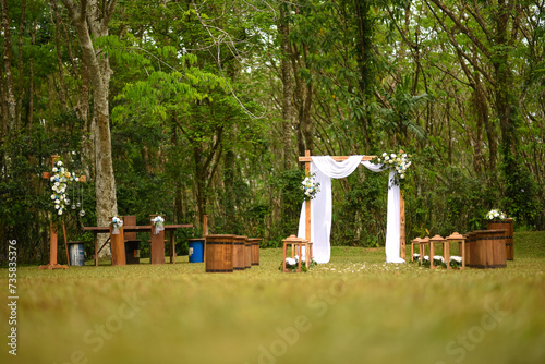 Beautiful view of an outdoor wedding setup with wooden seats and floral decorations