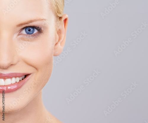 Beauty, cosmetics and half portrait of woman with smile, natural makeup or facial glow in studio mockup. Happiness, skincare and face of girl on grey background space for health shine and wellness.