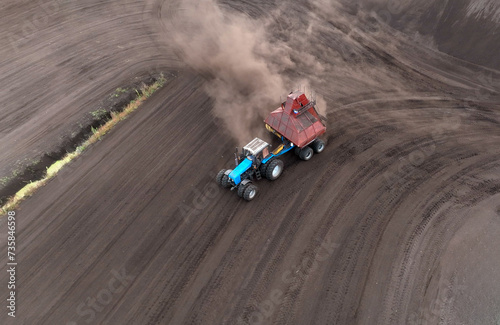 Peat Harvester Tractor on Collecting Extracting Peat. Mining and harvesting peatland. Area drained of the mire are used for peat extraction. Drainage and destruction of peat bogs.