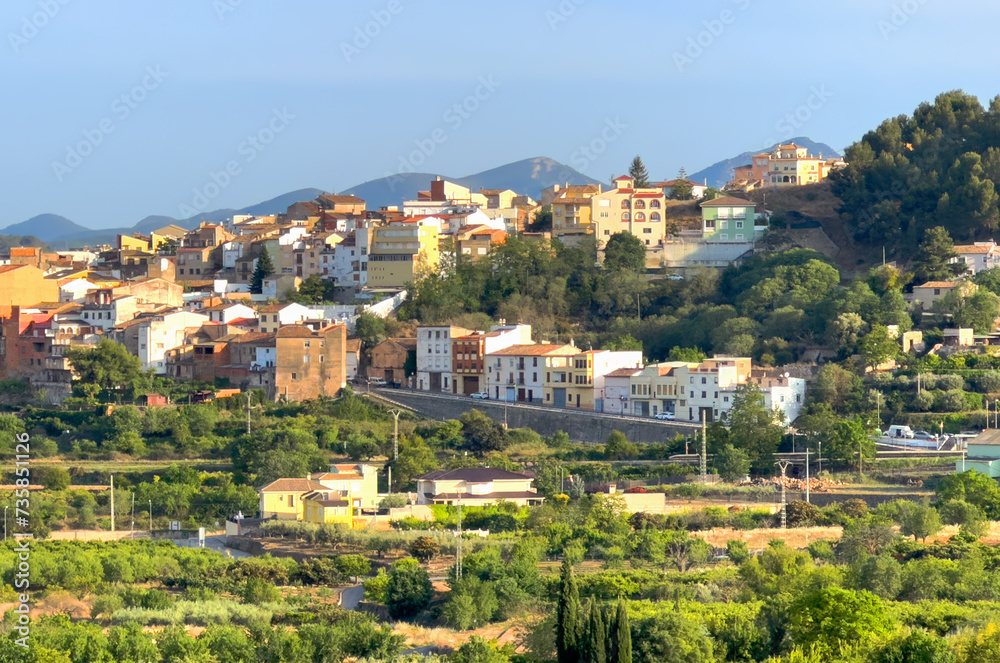 Rural landscape in Segorbe town. Farmhouse at vegetable field. Spain farmland. Cultivation of crops, production of food. House in farm field against backdrop of residential buildings in city