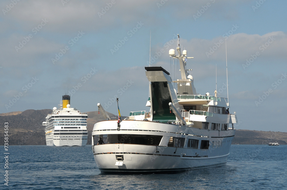 Naklejka premium Barcos de pasaje fondeados frente a la isla de Santorini en Grecia