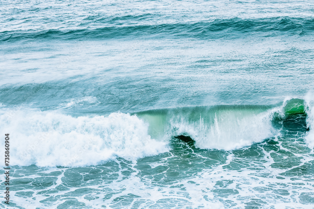 Fototapeta premium Wave splashing close-up. Crystal clear sea water, in the ocean in San Francisco Bay, blue water, pastel colors.