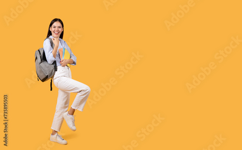 Joyful female student with backpack and copybooks smiling