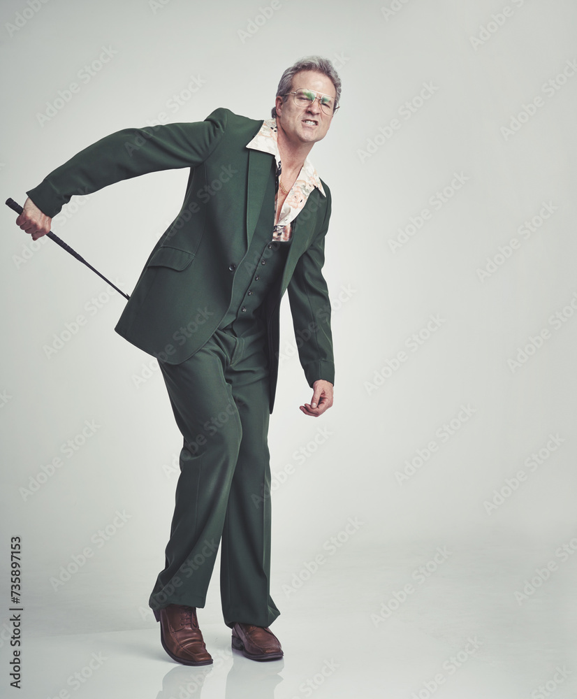 mature-man-and-fashion-with-whip-in-studio-with-suit-on-grey