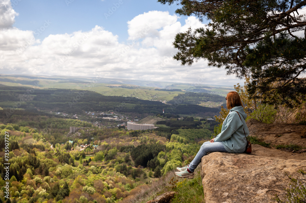 Woman sits on a mountain cliff