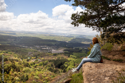 Obraz na płótnie Woman sits on a mountain cliff w salonie