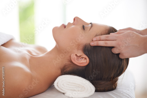 Head, massage and hands on woman in spa to relax on table for skin care, treatment or facial. Beauty, person and calm girl in luxury salon or resort on holiday or vacation with health and wellness