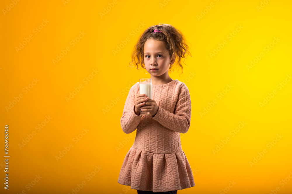 Child girl holding glass of milk. Nutrition and health concept Child girl holding glass of milk. Nutrition and health concept