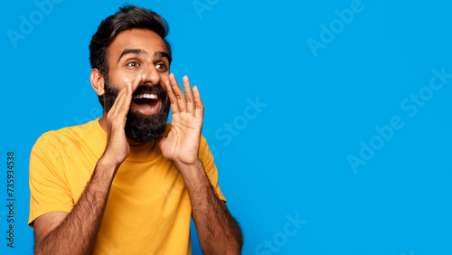 Middle aged indian man shouting message with hands around mouth