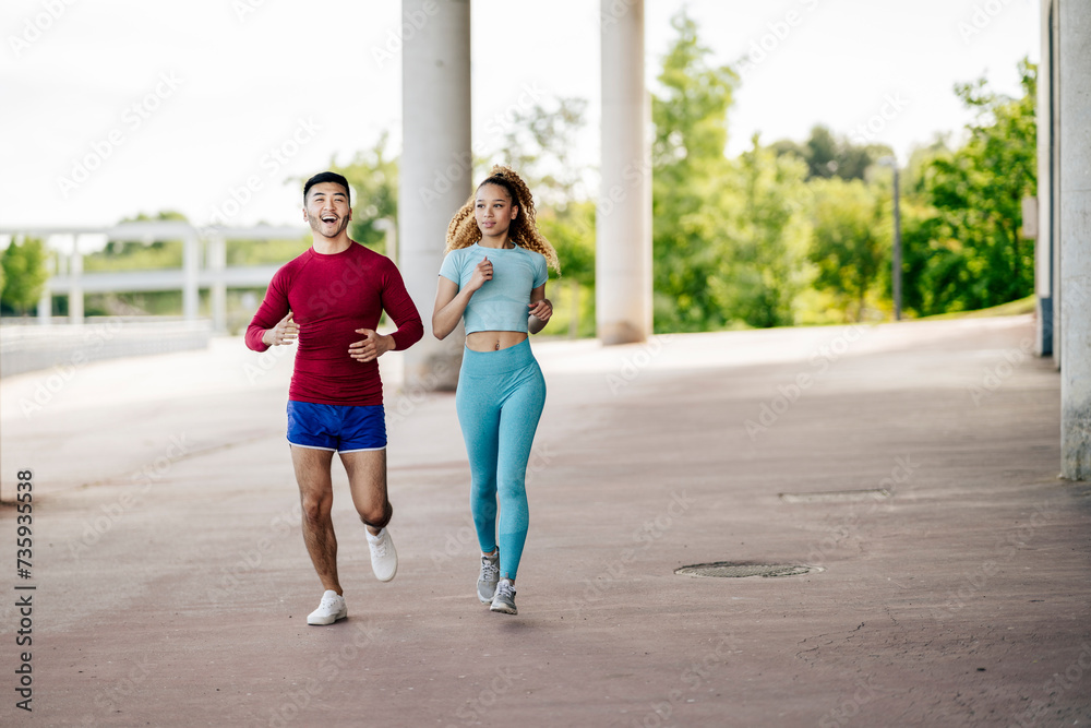 Fototapeta premium Multiethnic couple of friends exercising and joggingMultiethnic couple of friends exercising and jogging