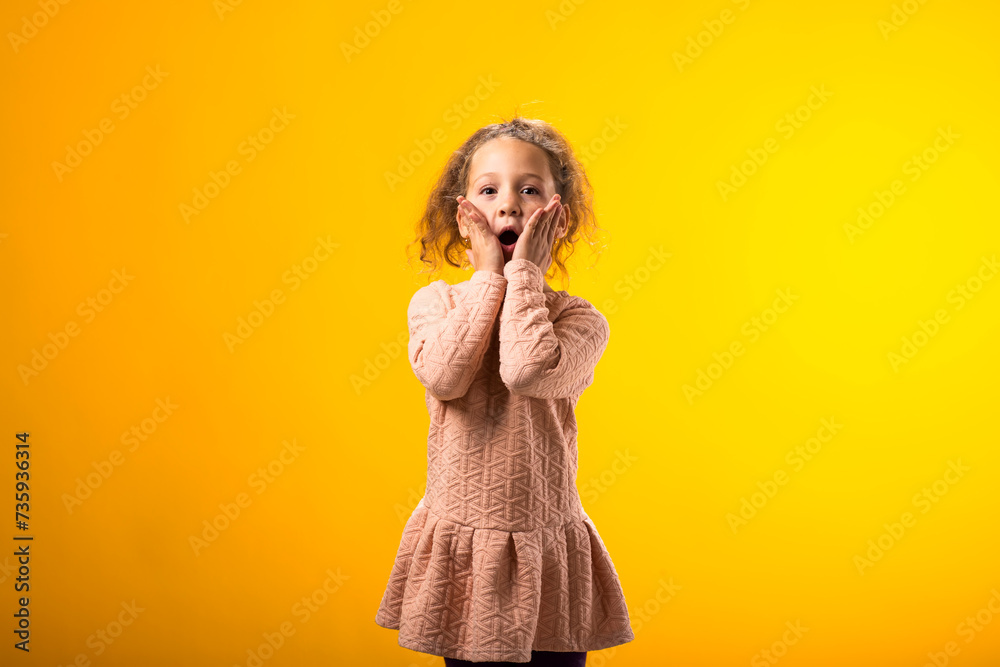 Surprised kid girl over yellow background. Astonishment emotion concept Surprised kid girl over yellow background. Astonishment emotion concept