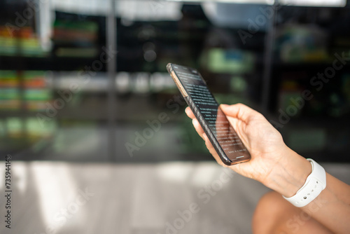 Close up view of hand of woman reading a online book on her smartphone © dtatiana