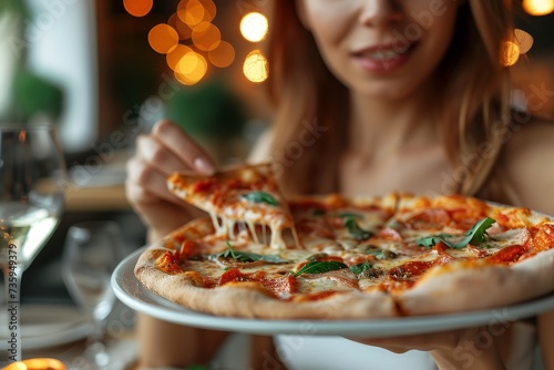 Close-up of pizza held by an unrecognizable woman ready to eat it