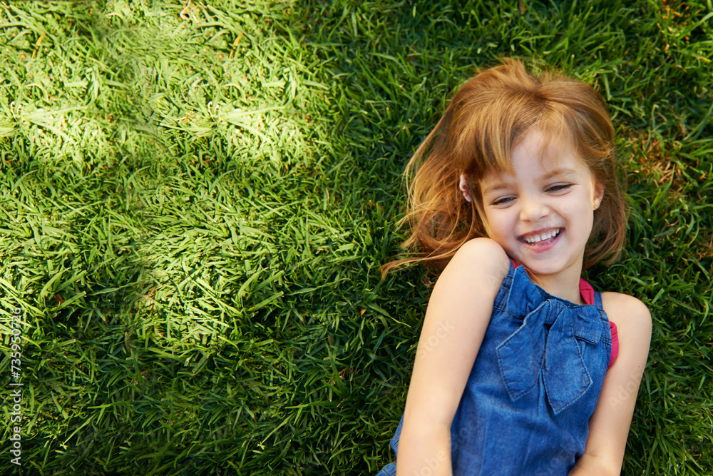 Child, grass and smile from above for relax holiday in countryside for summer vacation, nature or park. School kids, and happy on garden lawn in California environment for outdoor, sunshine or mockup Child, grass and smile from above for relax holiday in countryside for summer vacation, nature or park. School kids, and happy on garden lawn in California environment for outdoor, sunshine or mockup