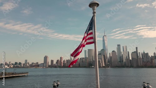 USA flag in NY. US American flag on NYC from drone. American Memorial, Veteran's Day, 4th of July. American Flag near New York City with Manhattan view. American Independence Day. Aerial View USA
