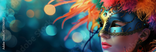 Beautiful young woman with creative make-up wearing multicolored carnival mask with feathers. Girl wearing costume celebrating carnival. Bokeh lights in background.