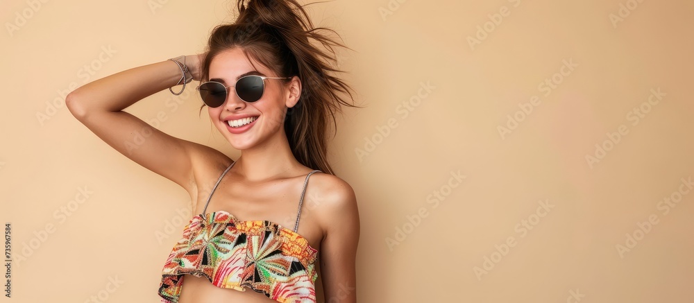 Trendy woman in stylish sunglasses and bikini top enjoying summer vacation on the beach Trendy woman in stylish sunglasses and bikini top enjoying summer vacation on the beach
