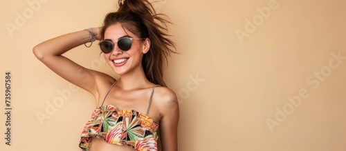 Trendy woman in stylish sunglasses and bikini top enjoying summer vacation on the beach © 2rogan