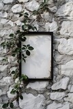 Blank white canvas framed with climbing plants on a textured stone wall.