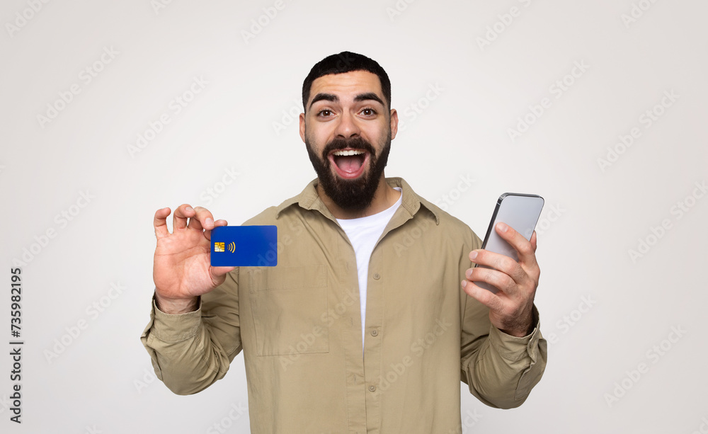 Glad shocked young middle eastern guy shopaholic with beard in casual with open mouth Glad shocked young middle eastern guy shopaholic with beard in casual with open mouth