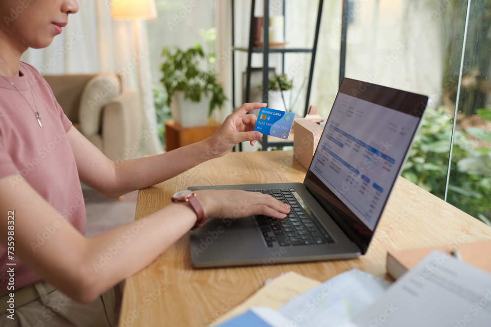 Fototapeta premium Woman paying for utility bills with credit card