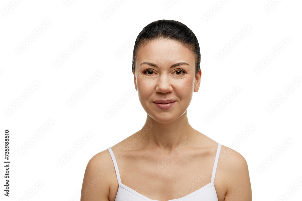 Pretty middle-aged woman with brunette hair in ponytail smiling against white studio background. Model with natural make up. Concept of facial treatment, beauty, spa, cosmetology, skincare, anti-aging Pretty middle-aged woman with brunette hair in ponytail smiling against white studio background. Model with natural make up. Concept of facial treatment, beauty, spa, cosmetology, skincare, anti-aging