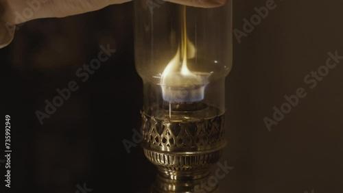 Kerosene lamp. A burning candle on the background of a kerosene lamp. Festive arrival. Beautiful handmade candles. Cozy atmosphere in the house. Old times