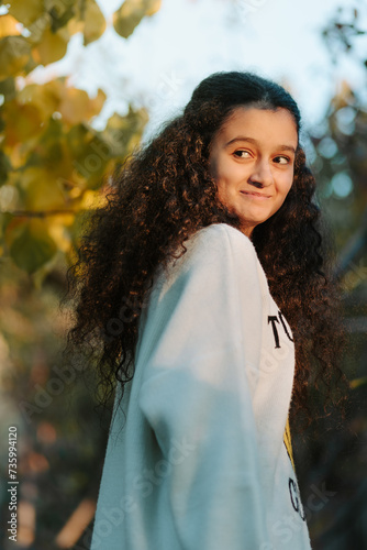 Obraz na płótnie Portrait of 13 years old girl full of emotions smiling and looking at sunset through the sunrays w salonie