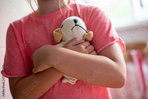 Young girl being shy hugging her teddies for comfort photo