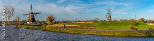Panorama of typical dutch rural landscape with traditional windmill and the river Gein in the town of Abcoude