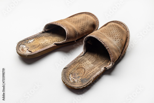 A pair of old, worn brown slippers. Close-up.