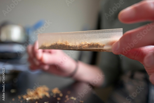 Young woman making a marijuana cigarette for health reasons