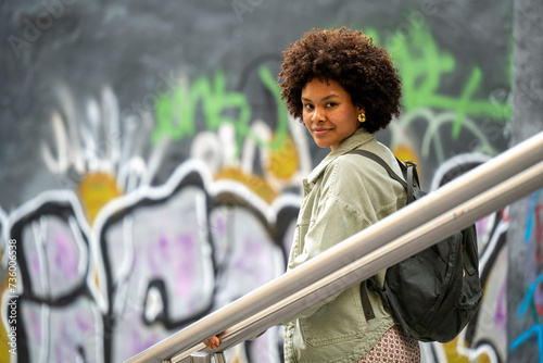 Trendy young mixed race African woman walking through town happy. photo