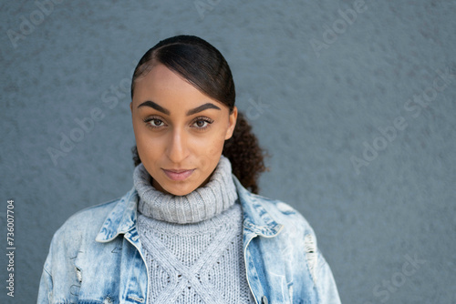 Mixed race attractive woman portrait against a grey wall for work