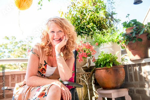 Portrait of a beautiful older woman with red hair in a summers dress looking healthy and happy photo