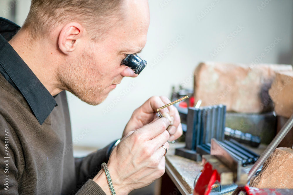Watch maker repairing a classic watch, authentic work place. Using a monocle and small tiny tools for repairs Watch maker repairing a classic watch, authentic work place. Using a monocle and small tiny tools for repairs