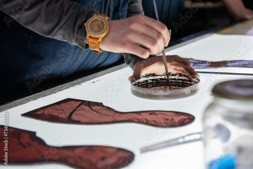 Apprentice female stained glass worker being taught lessons from teacher. Leanring over lightbox colouring in glass photo