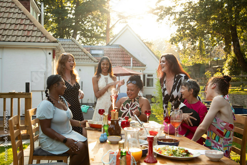 A mixed gathering of women laughing and having fun at a summer garden birthday party celebration lunch photo