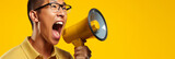 Energetic asian man exclaiming into megaphone on vibrant yellow background, space for text