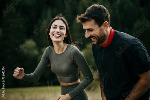 A diverse pair happily running side by side on a hillside trail